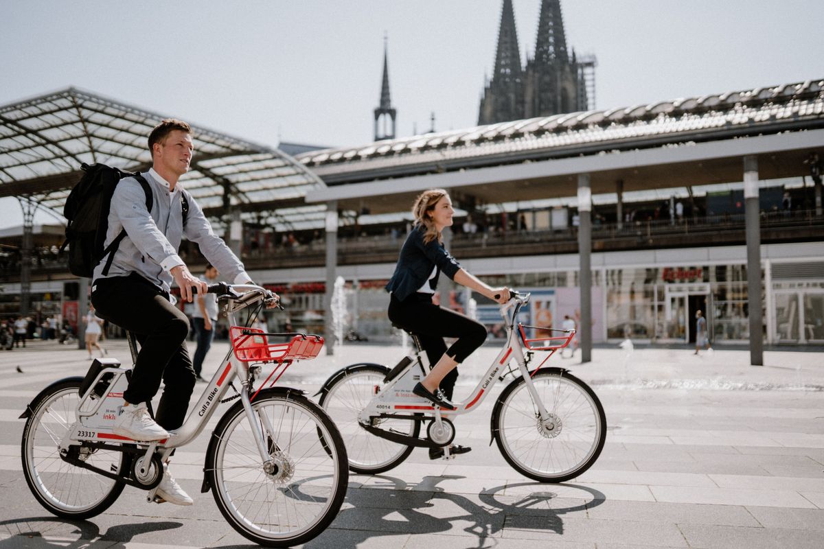 Mann und Frau fahren mit ihren Call a Bike Fahrrädern vom Bahnhof
