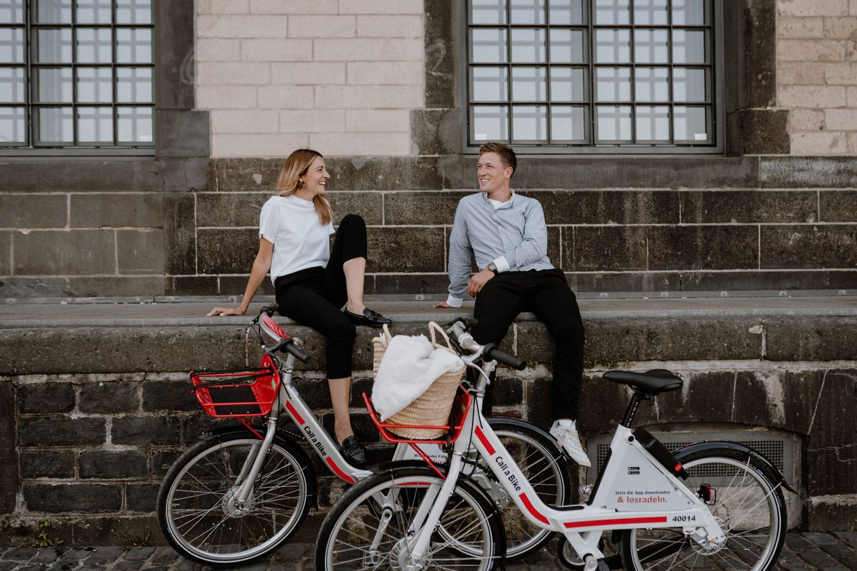 Frau und Mann sitzen vor Gebäude mit ihren Call a Bike Fahrrädern