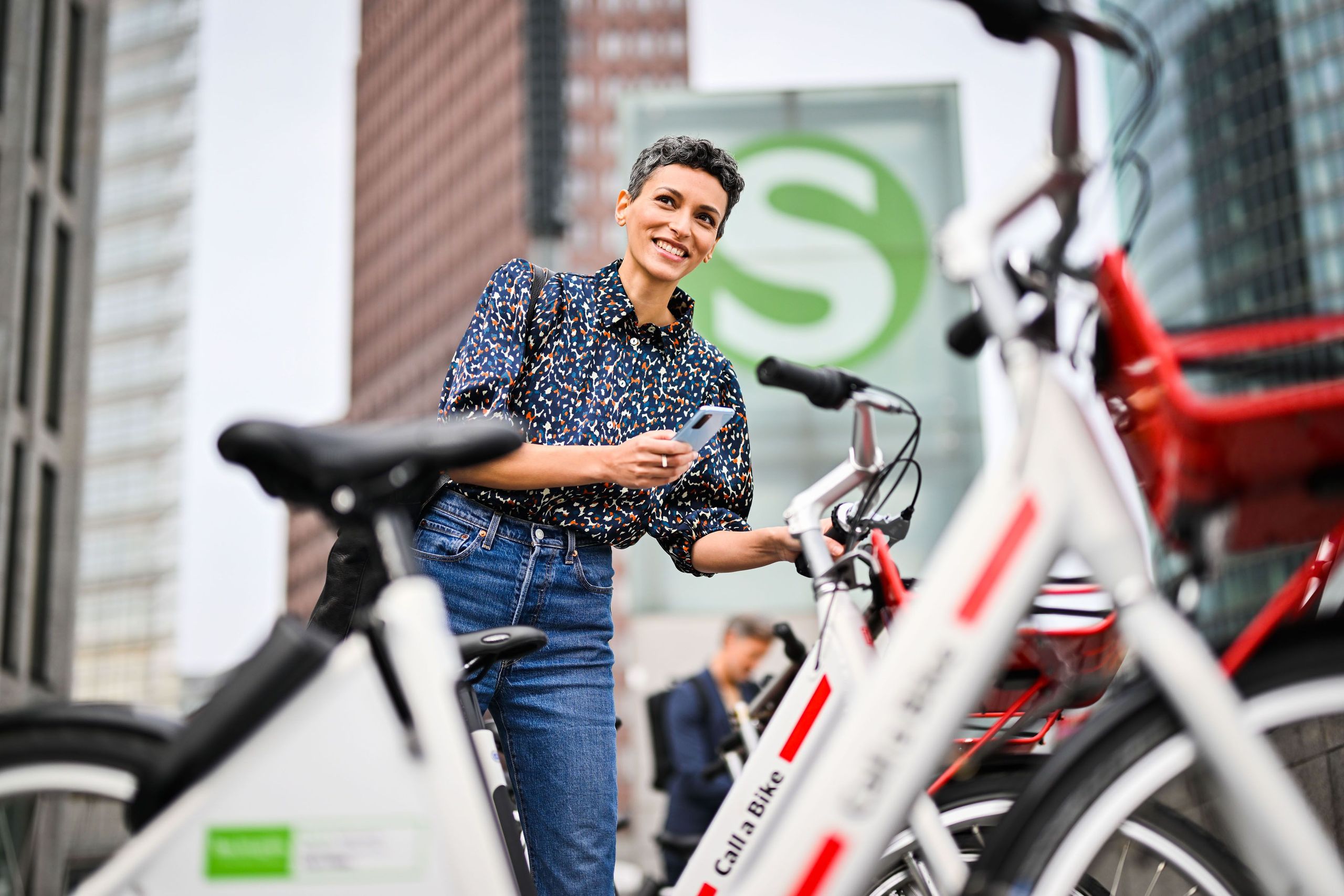 Eine Frau entleiht mit ihrem Handy ein Call a Bike