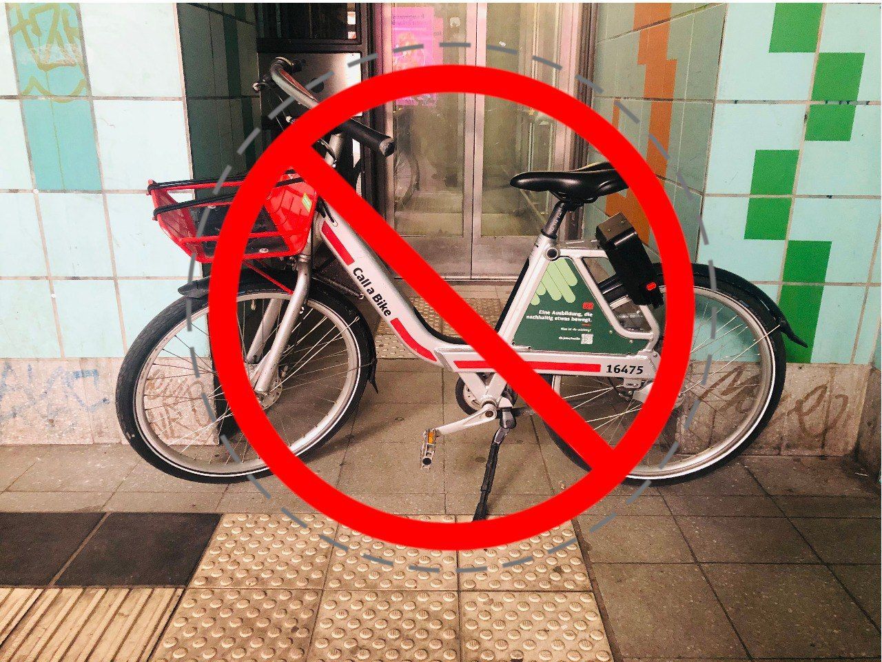 A bike parked in front of an elevator, obstructing access.