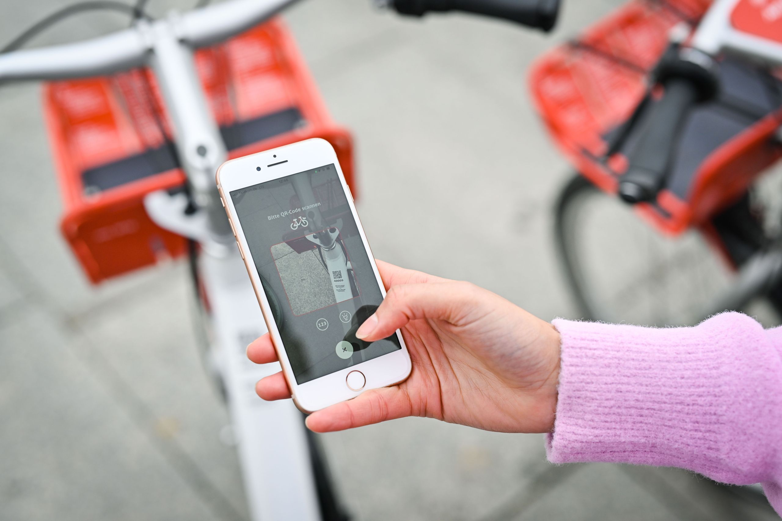 Frau scannt QR Code über die App